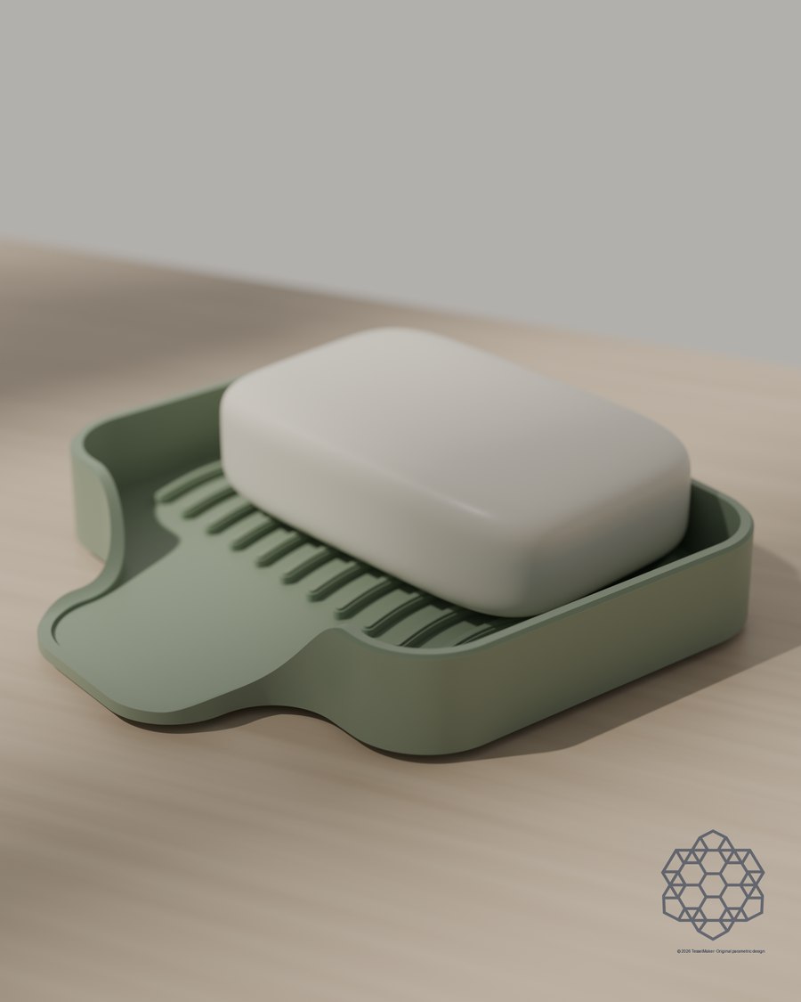 Cascade flexible soap dish in sage with a bar of soap resting on its wave-ribbed deck, on a sunlit wooden table.